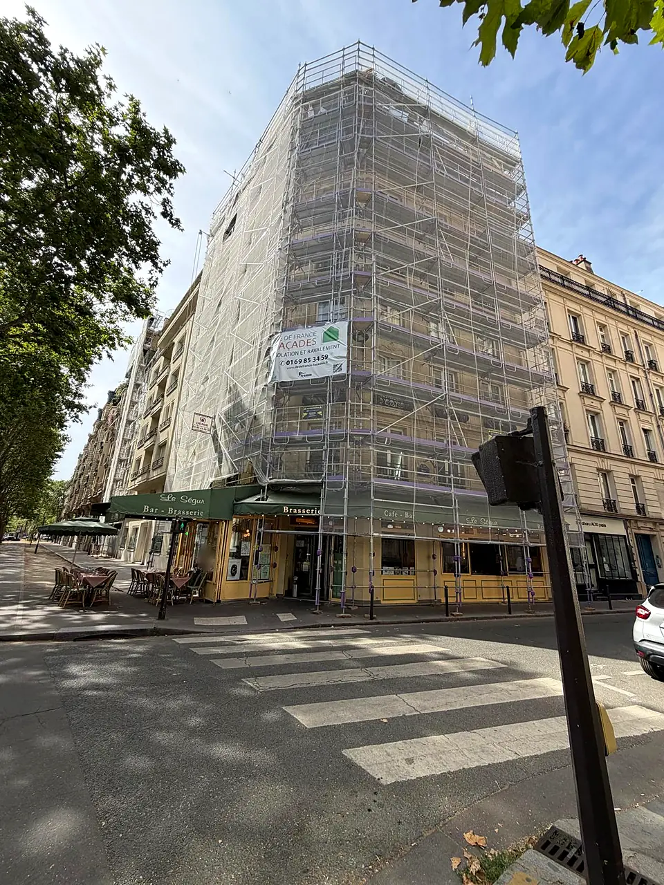 Immeuble d'angle en pierre de taille avenue de Suffren, Paris 15ᵉ, sous échafaudage bâché pendant le nettoyage laser de la façade — avant